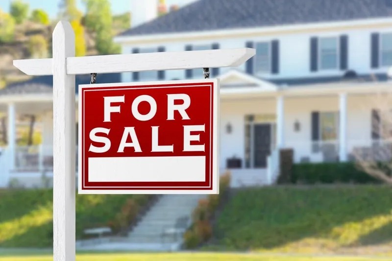 For Sale sign standing in front of a house before a pre purchase building and pest inspection