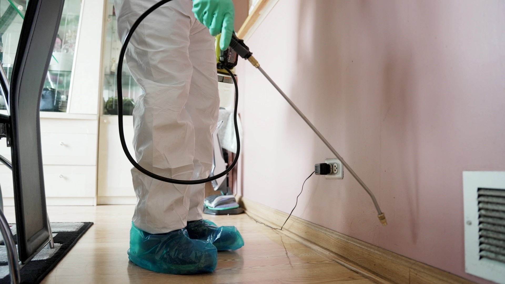 Dean from Carlton Pest Control spraying a general pest treatment along an interior skirting board